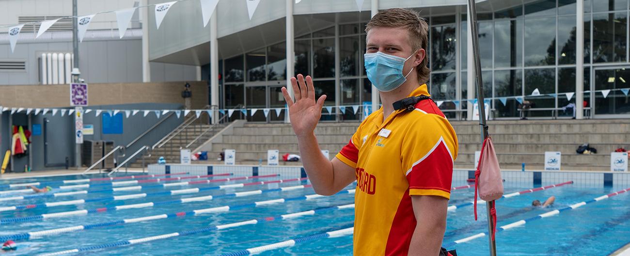 Lifeguard at outside pool welcoming you back with a wave