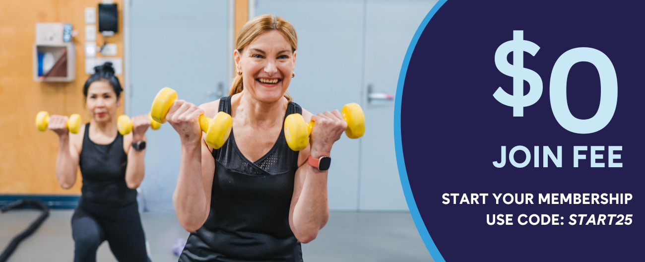 Two women in a bright fitness studio performing dumbbell exercises with yellow weights, smiling at the camera. Text overlay displays '$0 JOIN FEE' and 'START YOUR MEMBERSHIP USE CODE: START25' against a dark blue curved design element.
