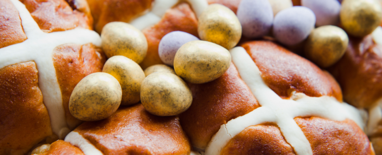 image of hot cross buns with easter eggs scattered on top
